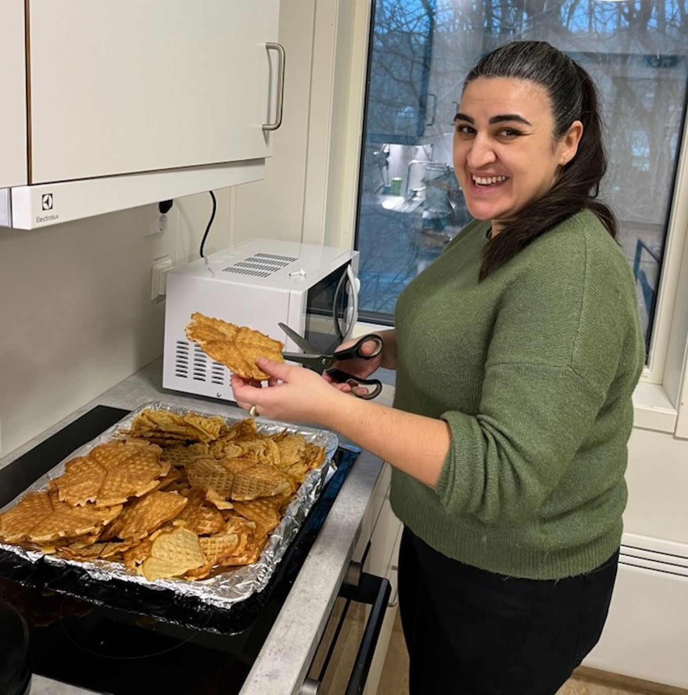 en person som holder et brett med småkaker en person som holder et brett med småkaker