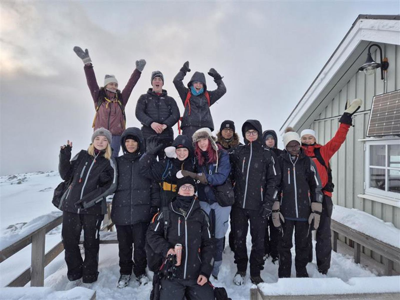 en gruppe mennesker som poserer for et bilde i snøen