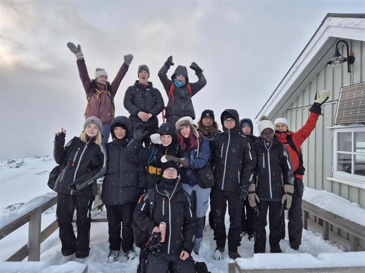 en gruppe mennesker som poserer for et bilde i snøen