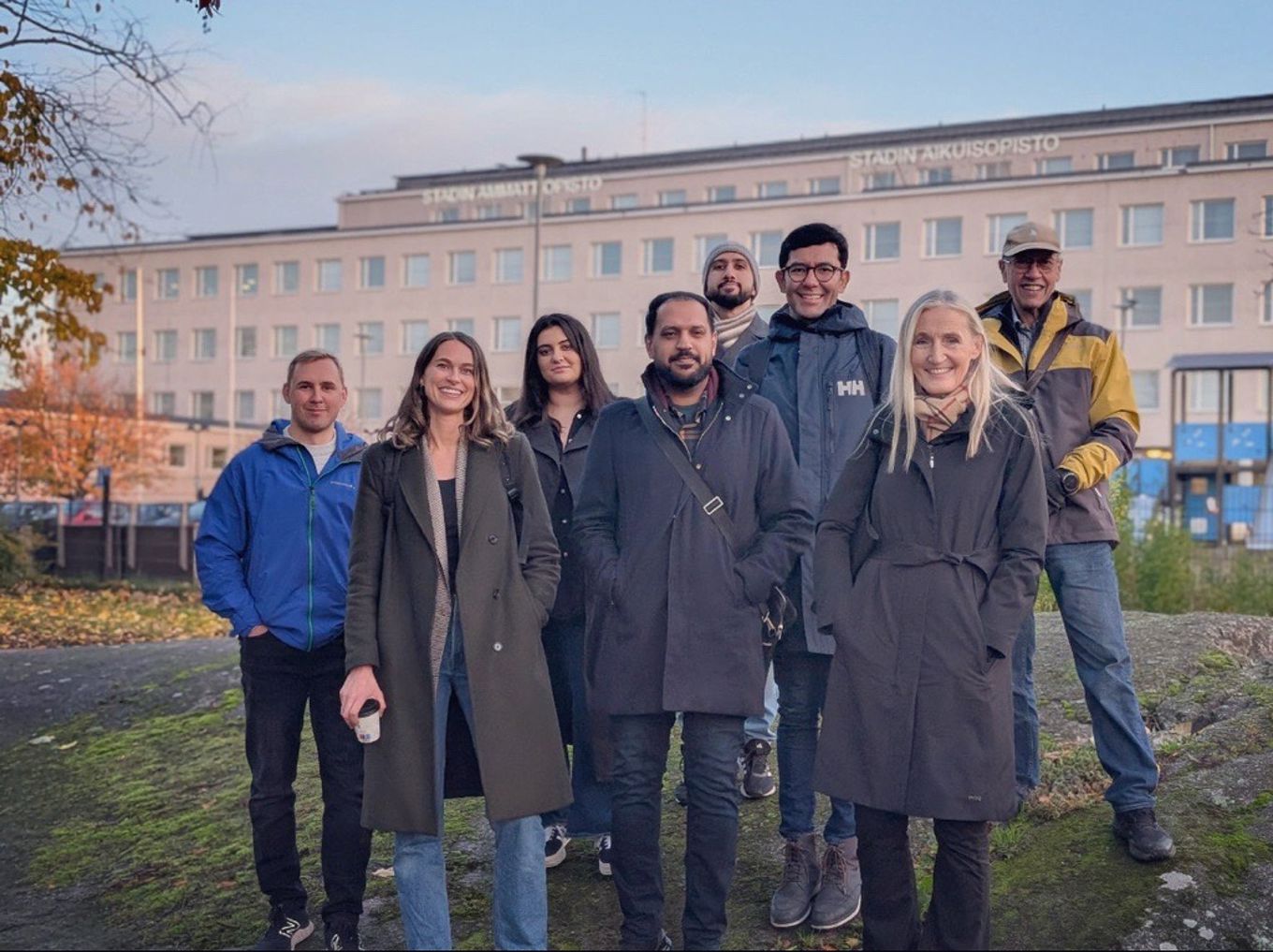 en gruppe mennesker som poserer for et bilde foran en bygning