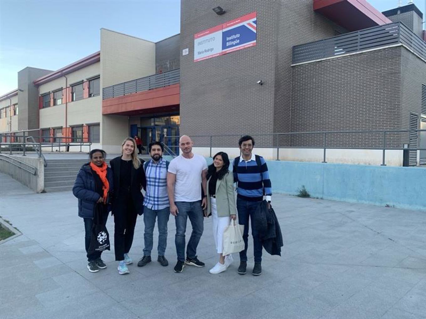 en gruppe mennesker som poserer for et bilde utenfor en bygning