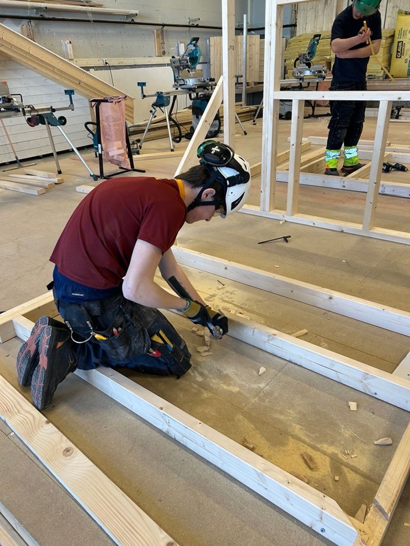 en person med hjelm som jobber på et stykke tre en person med hjelm som jobber på et stykke tre